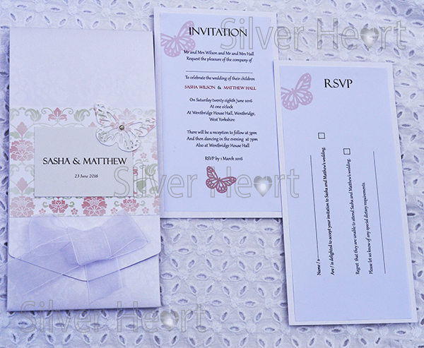 Image of Broderie Antique Rose long pocketfold invitation, decorated with flower and vine paper, organza bow , butterfly and gem. Also showing two inserts: Invitation and RSVP.